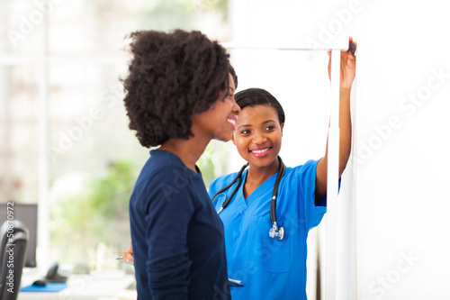 Photography african nurse measuring patient's height