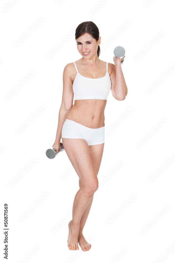Fototapeta premium Young Woman Lifting Dumbbells