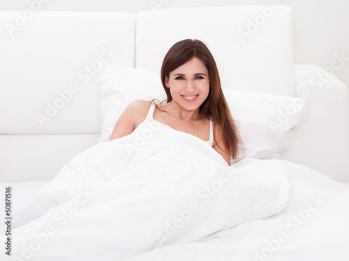Portrait Of Happy Woman On Bed