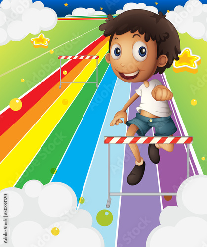 A little boy near the stripe hurdle