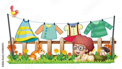 A boy and a bunny in a garden with hanging clothes