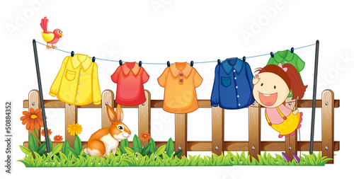 A lady hanging her clothes near the garden with a rabbit