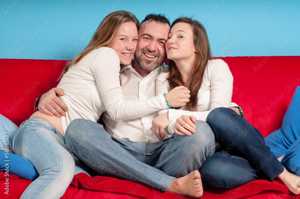 happy father and daughters on the couch happy father and daughters on the couch