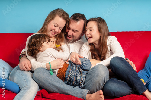 happy father and daughters on the couch