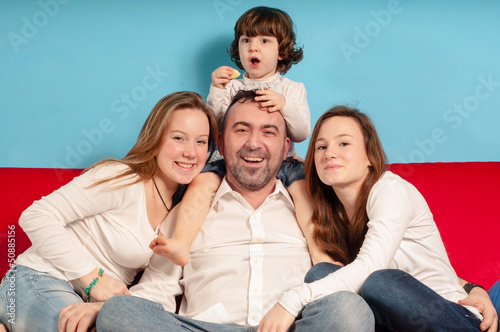 happy father and daughters on the couch