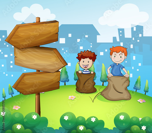 Two boys playing sack race near the arrow boards