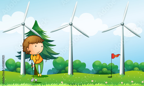 A girl playing golf near the windmills