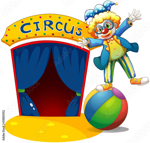 A clown at the top of the ball beside a circus house