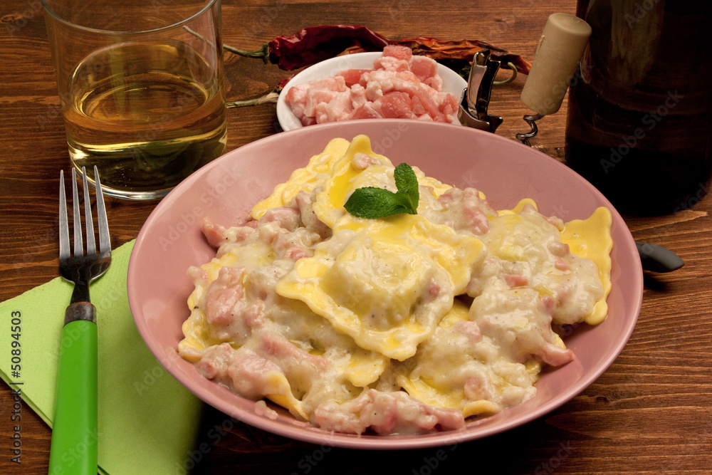 Tortelli di carne al sugo di panna e pancetta affumicata Stock Photo