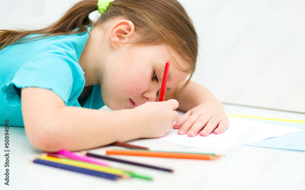 Little girl is drawing using pencils Little girl is drawing using pencils