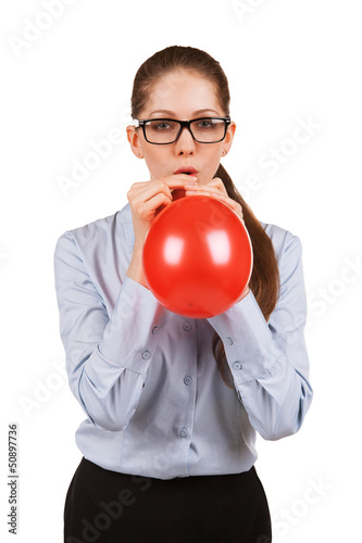 Girl with glasses inflating a red ball photo