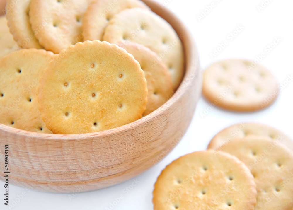 Crackers in a wooden bowl on white background Crackers in a wooden bowl on white background