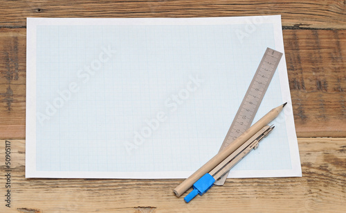 Still life photo of engineering graph paper with pencil, compass