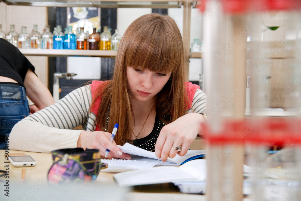 A student at work in laboratory of chemistry studies the records A student at work in laboratory of chemistry studies the records