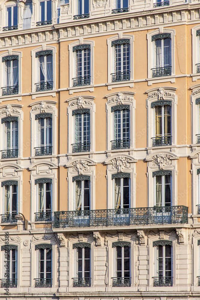 façade jaune d'immeuble ancien avec fenêtres à Lyon