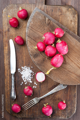 Still life with radishes and salt on a wooden background