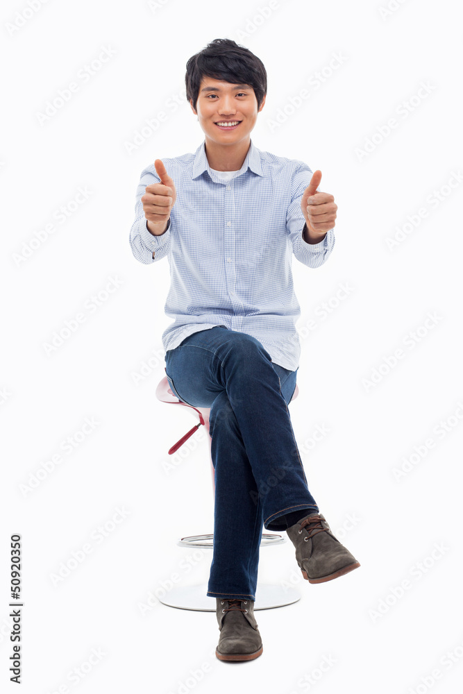 Young asian man showing thumb. Young asian man showing thumb.