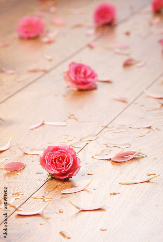 Spa background of the wooden floor and some flowers and petals
