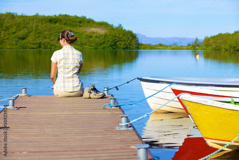 Fototapeta premium Woman sitting on a pier
