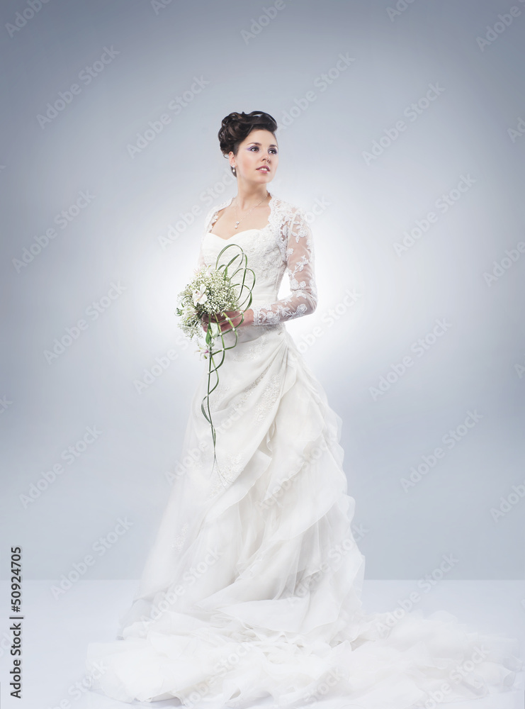 Young and beautiful bride standing with a flower bouquet Young and beautiful bride standing with a flower bouquet