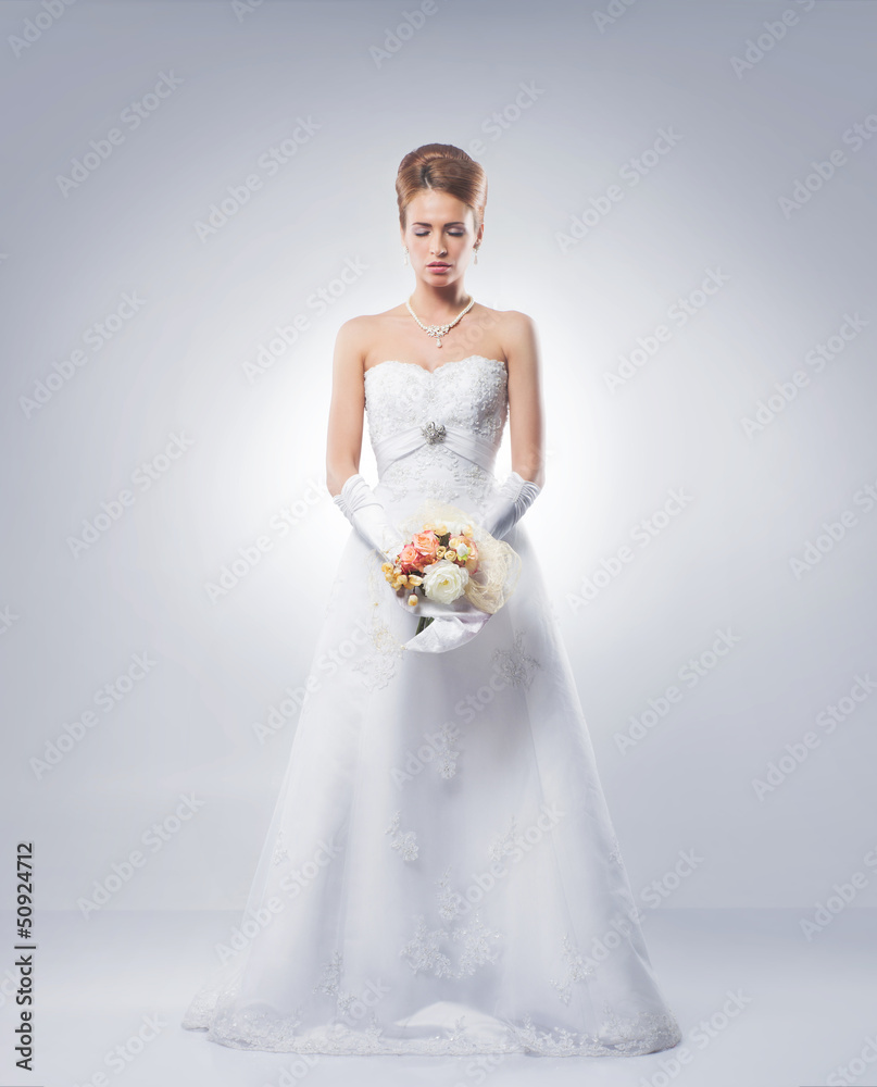 Young and beautiful bride standing with the flower bouquet Young and beautiful bride standing with the flower bouquet