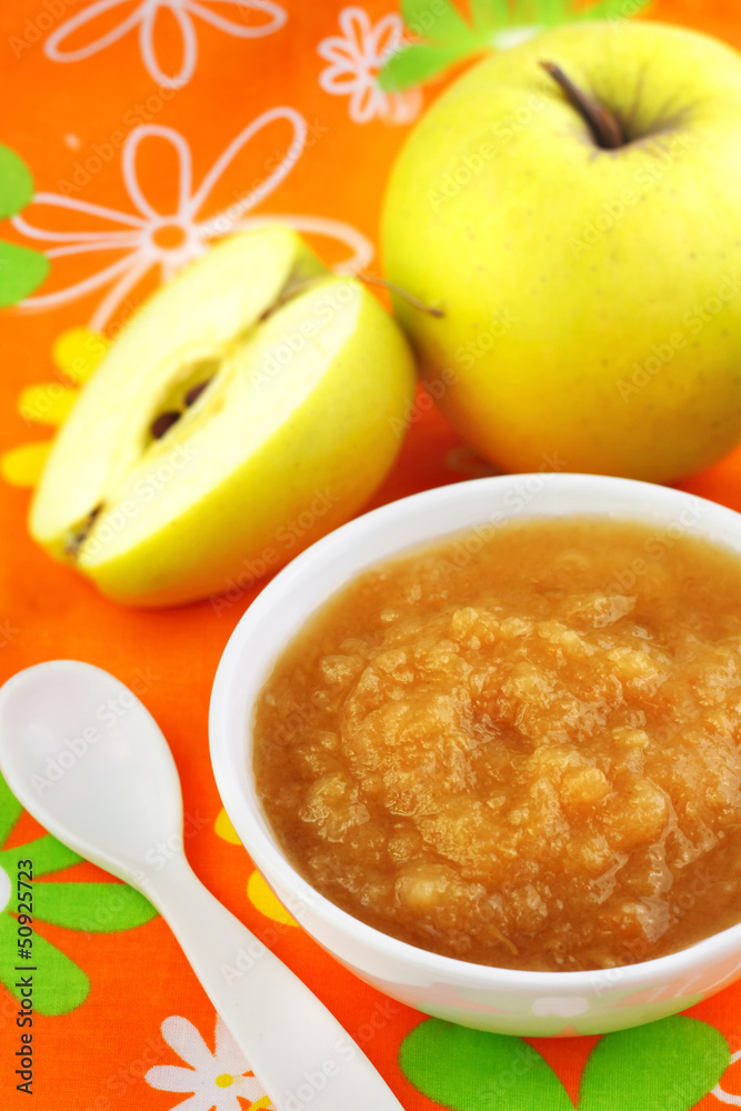 Homemade apple puree in a bowl on colorful tablecloth Homemade apple puree in a bowl on colorful tablecloth