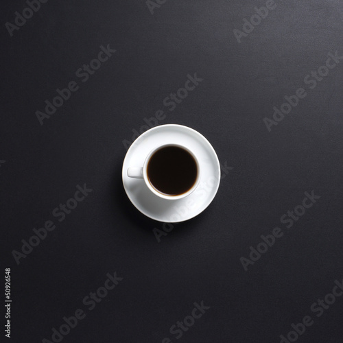 A white cup of tasty coffee on a dark grey background