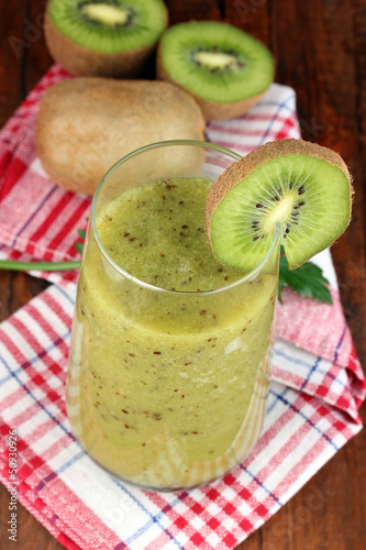 Glass of fresh kiwi juice on wooden table