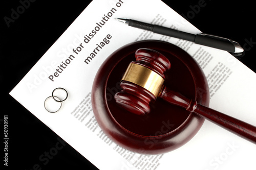Divorce decree and wooden gavel on black background