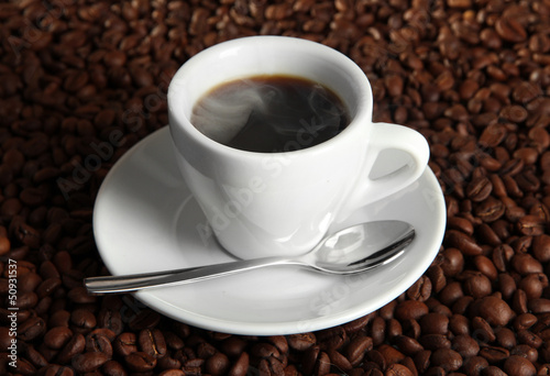 Cup of coffee on coffee beans background © Africa Studio