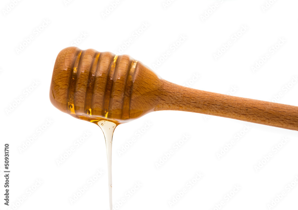 Honey dripping from a wooden honey dipper Honey dripping from a wooden honey dipper