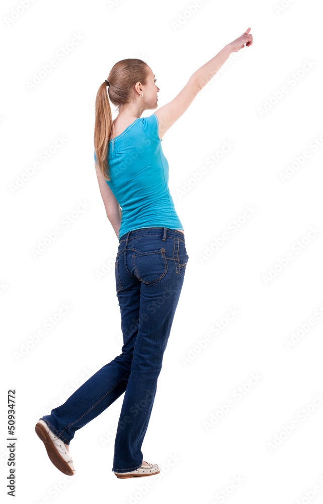back view of walking woman in jeans and shirt pointing back view of walking woman in jeans and shirt pointing