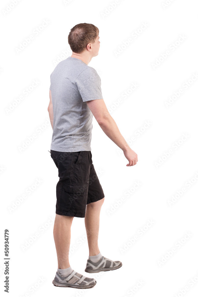 Back view of walking handsome man in shorts and sneakers Back view of walking handsome man in shorts and sneakers