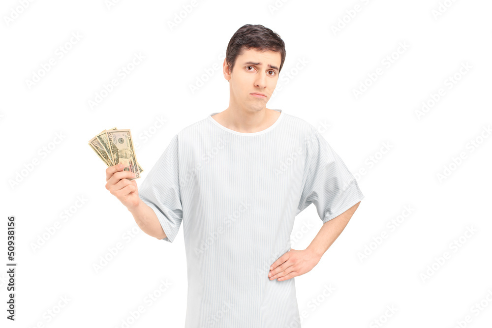 A sad male patient in a hospital gown holding US dollars A sad male patient in a hospital gown holding US dollars