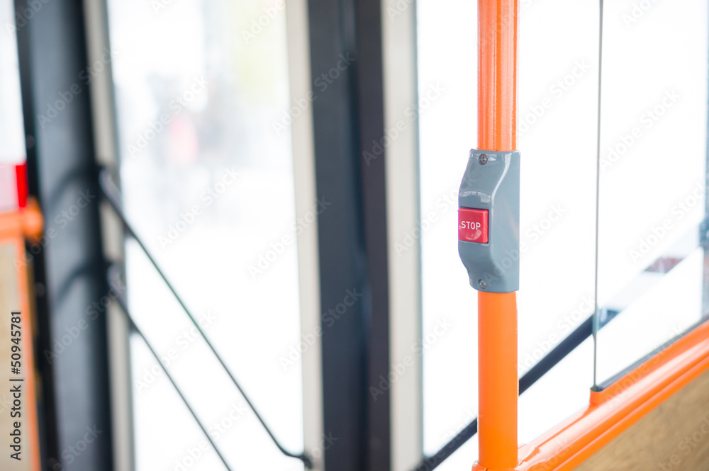 Stop alert button on orange handle in modern city bus Stop alert button on orange handle in modern city bus