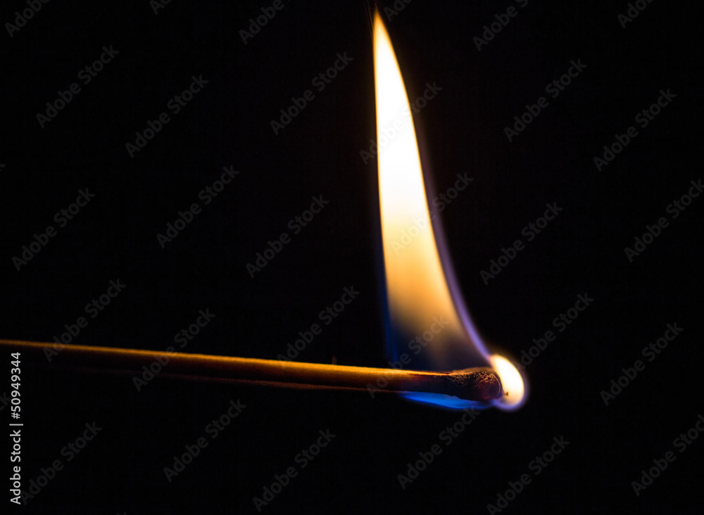 Burning match with a black background.