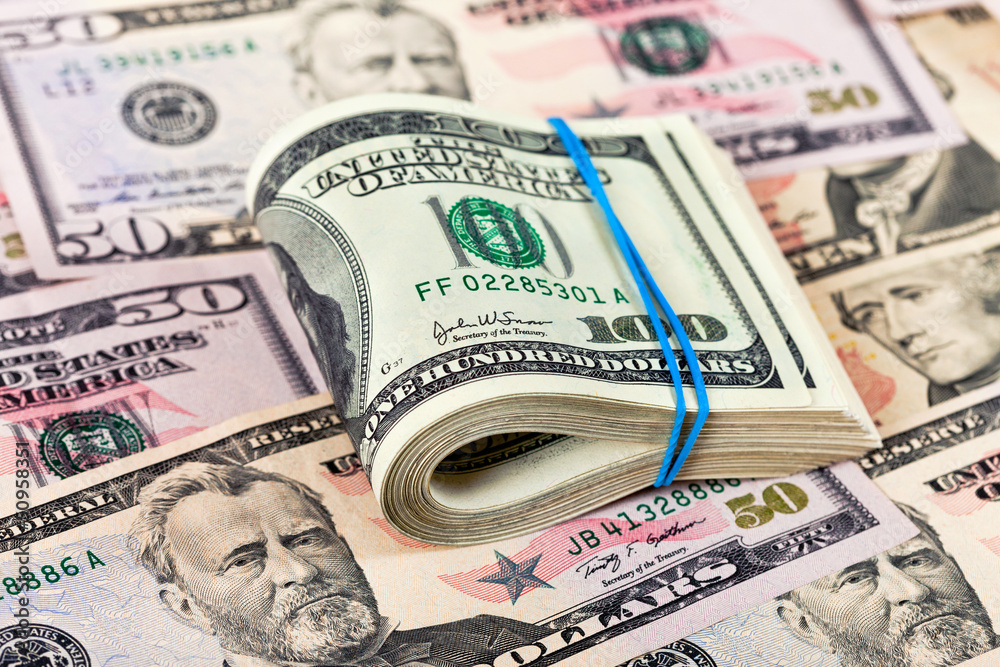 Fototapeta premium Stack of one hundred dollar bills row on money background