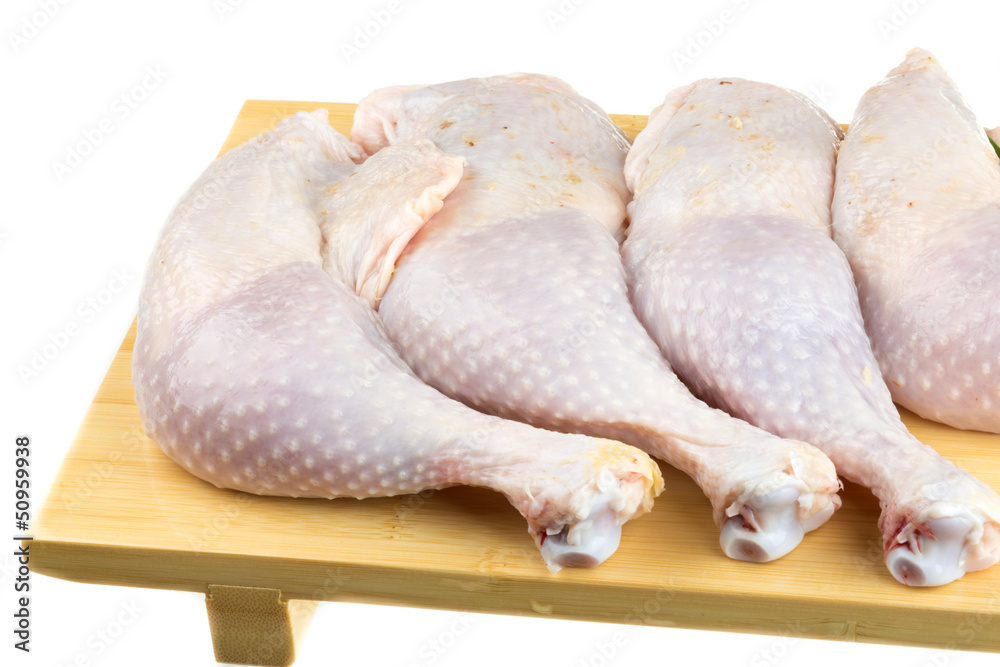 Fresh raw chicken wings on chopping board with roma tomatoes