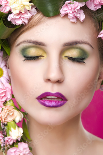 beauty woman portrait with wreath from flowers on head pink back