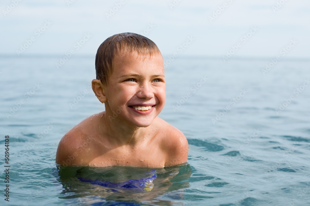 Boy swims in the sea.