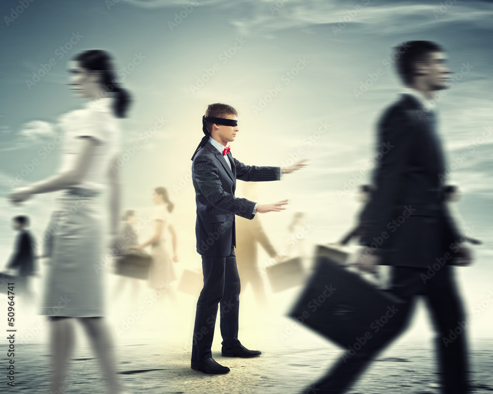 Businessman in blindfold among group of people