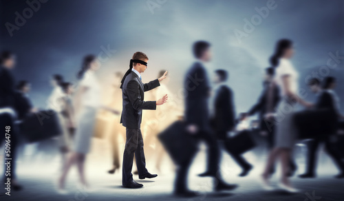 Businessman in blindfold among group of people