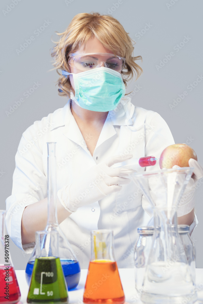 woman in protective mask tests apple specimen in chemical lab woman in protective mask tests apple specimen in chemical lab