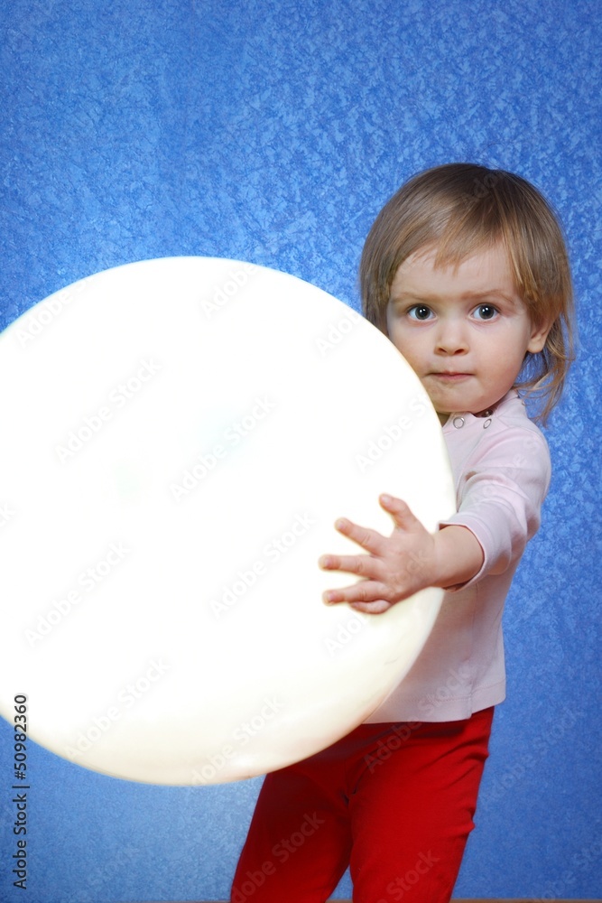 Child with ball, portrait on a blue background
