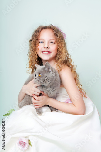 child in white dress with British cat