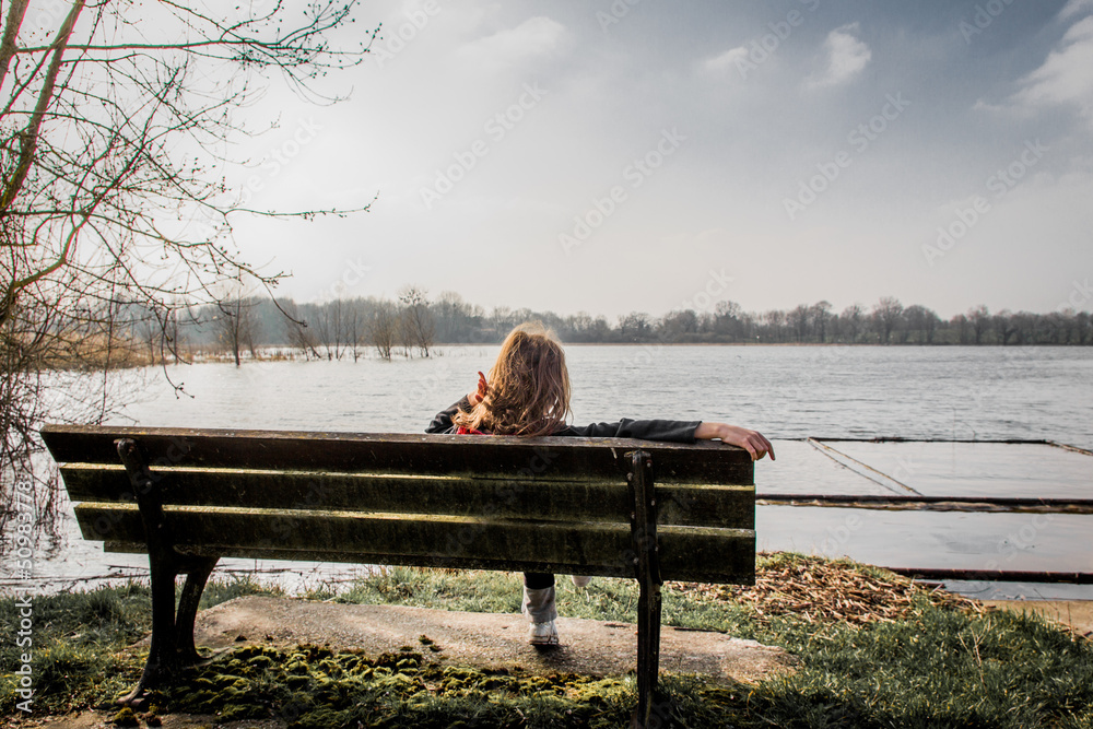Petite fille sur un banc au bord d'un étang dans les Dombes Stock Photo ...