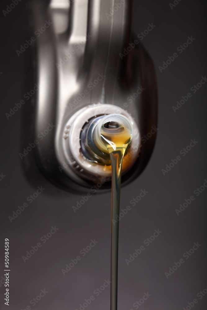 Can with car engine oil pouring black background