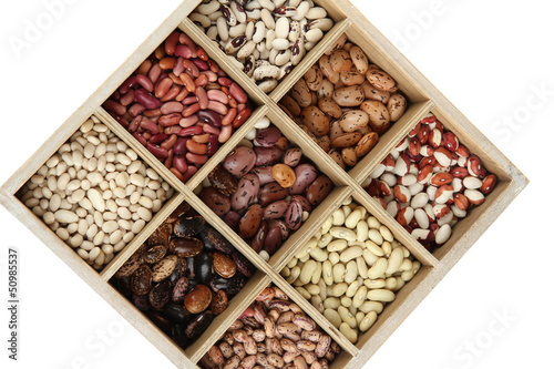 Diverse beans in wooden box sections isolated on white