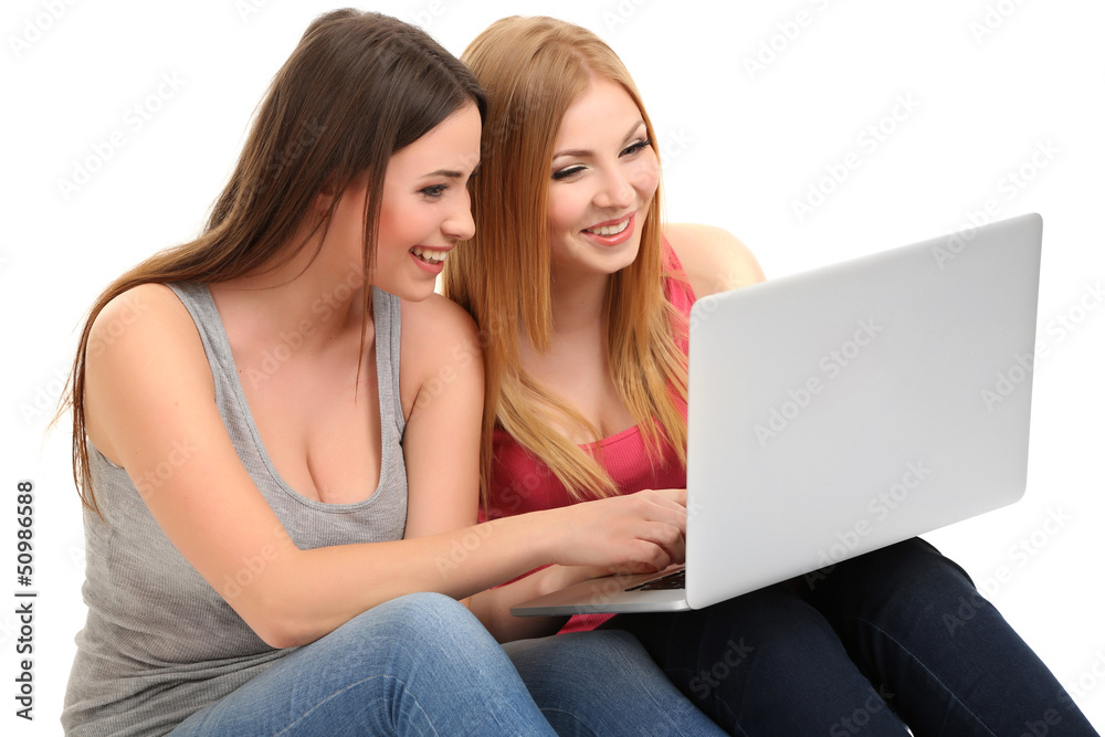 Two girl friends with with laptop isolated on white Two girl friends with with laptop isolated on white