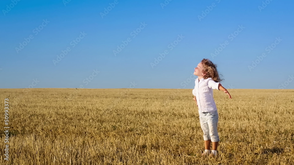 Happy child enjoying the sun in summer field. Slow motion Happy child enjoying the sun in summer field. Slow motion
